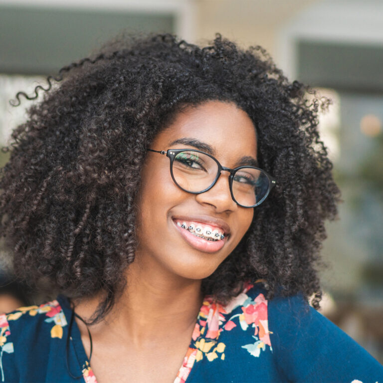 Smiling Teen Girl Wearing Braces And Glasses