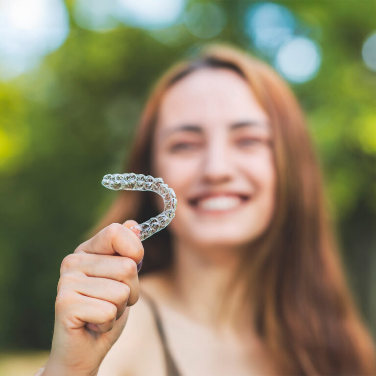 Woman Holding Clear Aligner