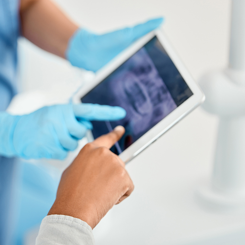 Shot Of A Young Woman Looking Over Her Dental X Rays With Her Doctor Using A Tablet