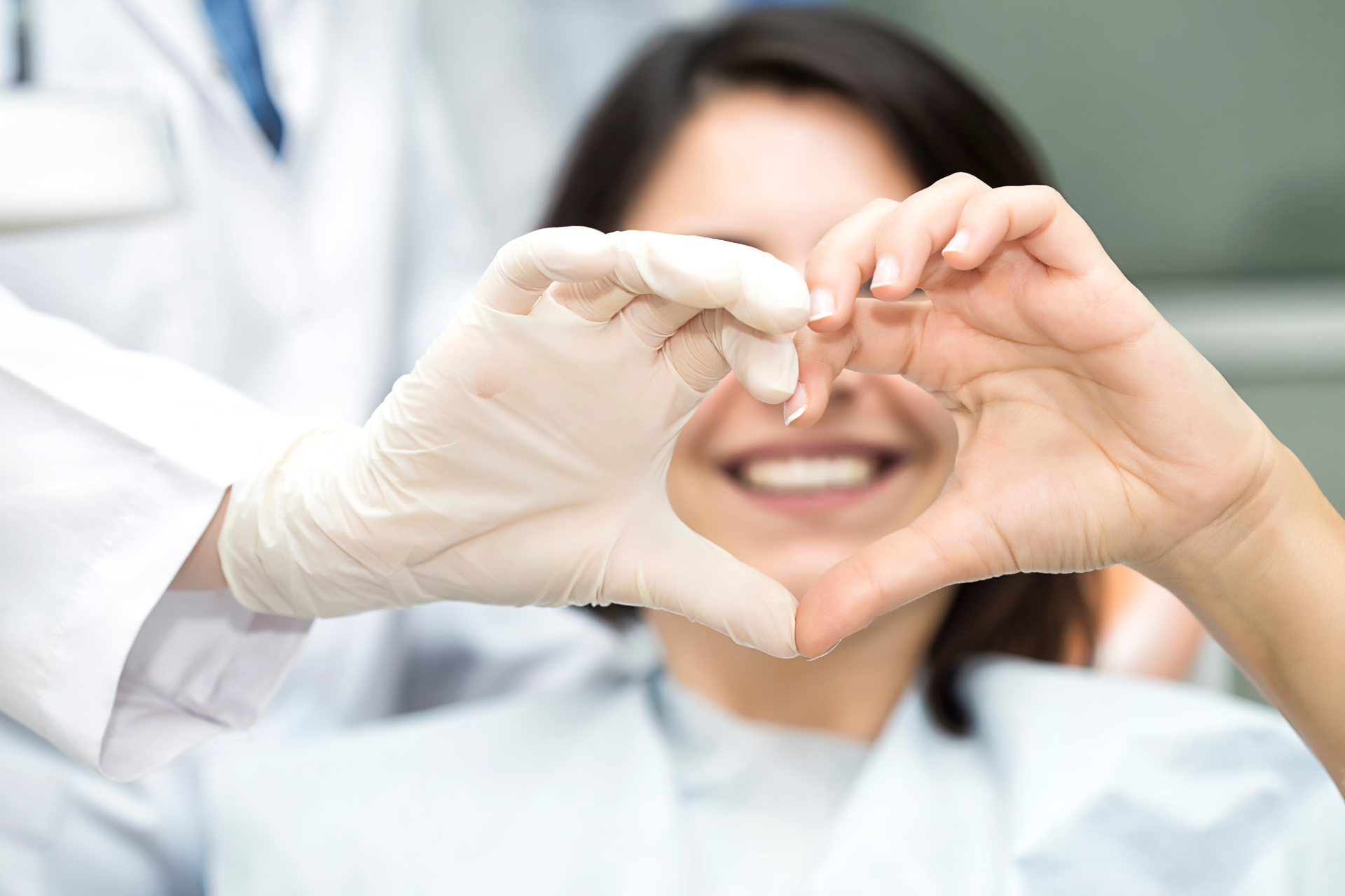 Orthodontist With Patient Making Heart Shape With Her Hands