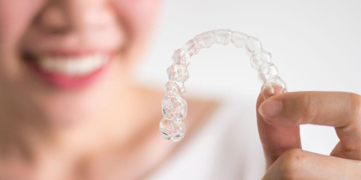 Woman Holding Clear Aligners
