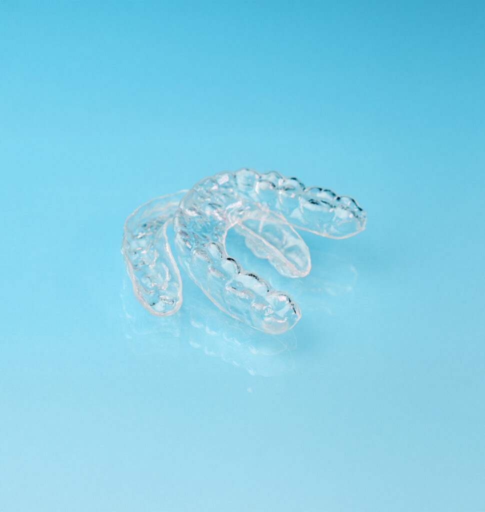 Removable aligners on the blue background with copy space. Orthodontic treatment for beautiful smile